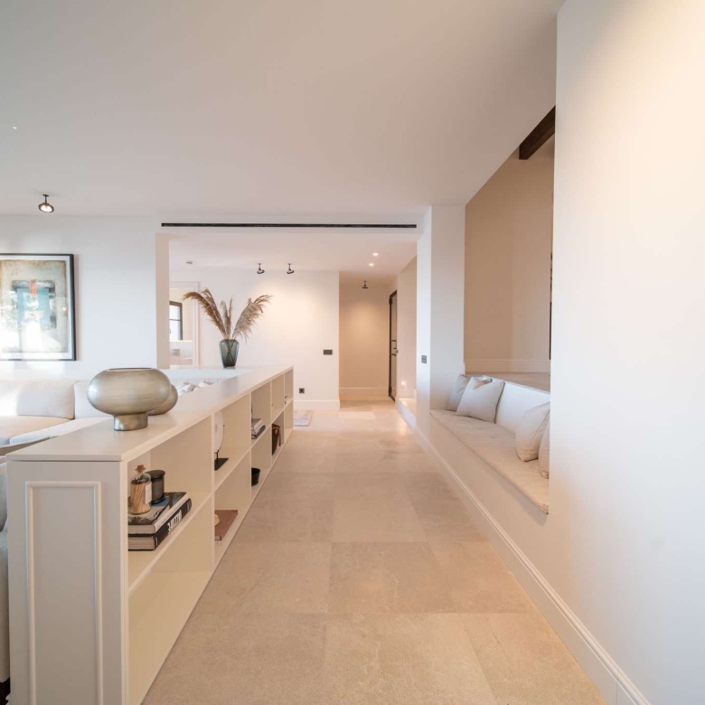 Open-plan living room flooded with natural light and sea views through full-height glazing, luxury villa Cala Llamp, Mallorca