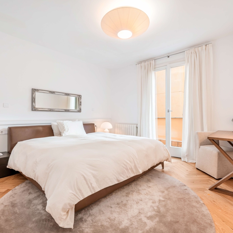 Master bedroom with parquet flooring and tall windows in Palma old town